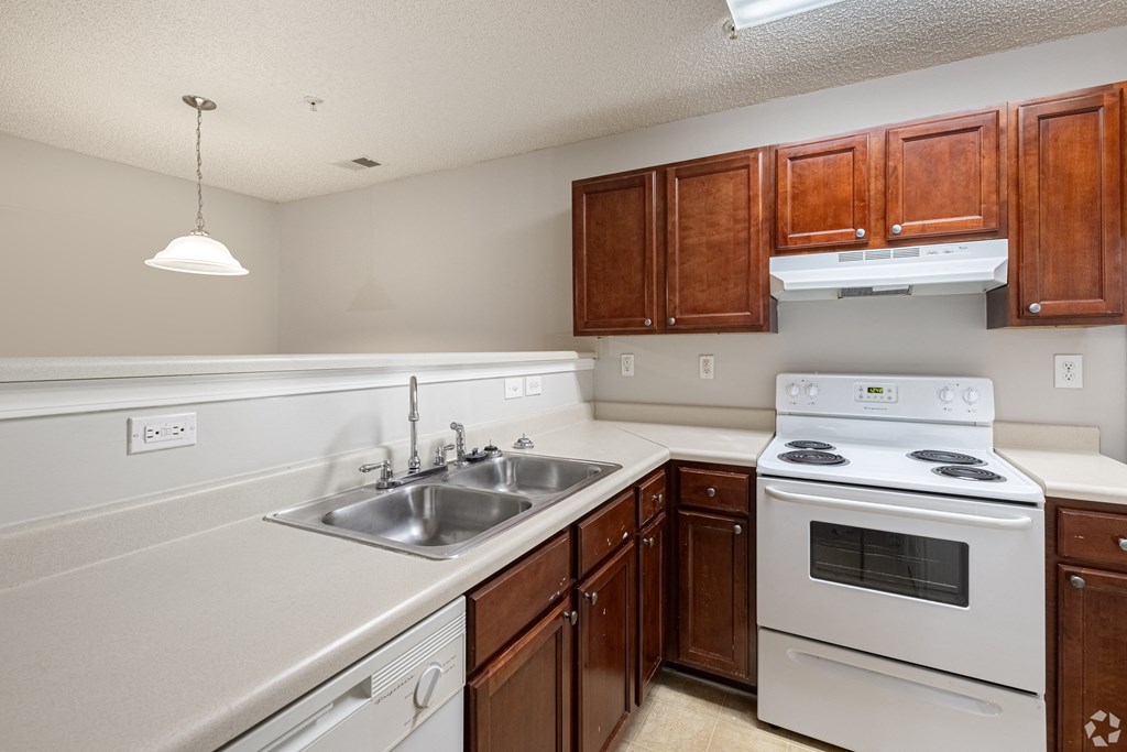 Kitchen with white appliances and wooden cabinets at Cross Creek Apartments, Beaufort, SC, South Carolina, 29906