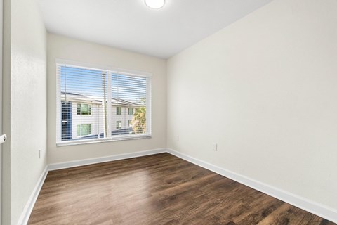 A room with a window overlooking a building.