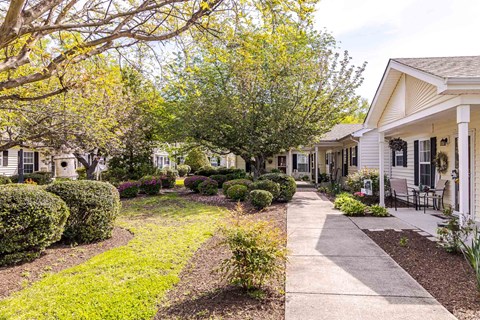 A row of houses with a sidewalk in front.