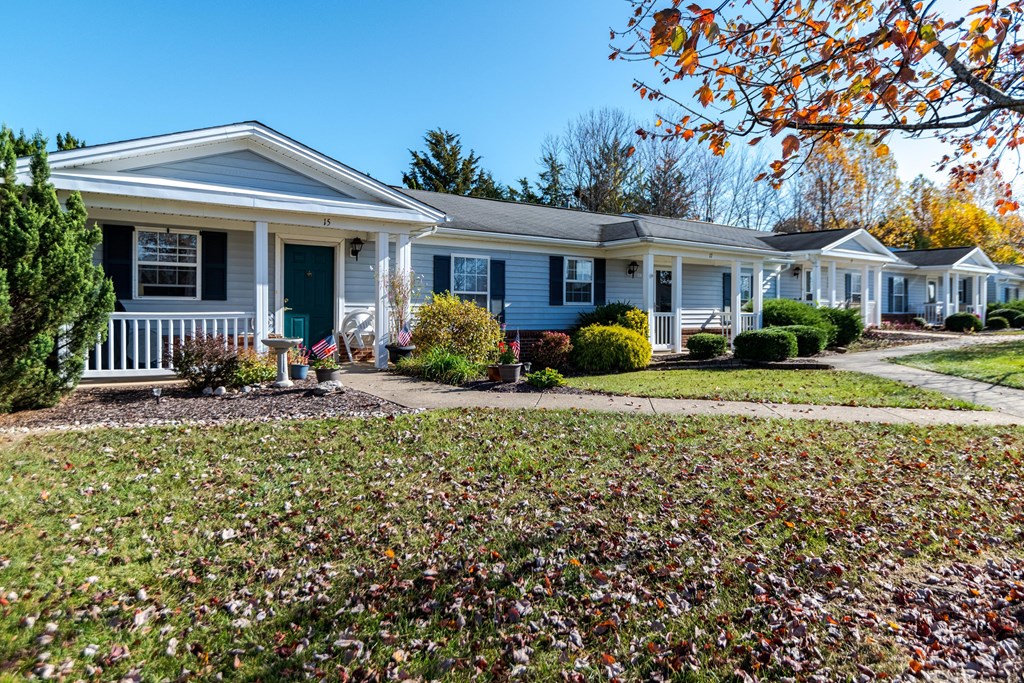 A row of houses with a green lawn in front at English Oaks Apartments, Fredericksburg, VA, 22406
