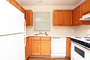 A kitchen with wooden cabinets and white appliances.
