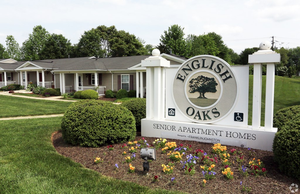 A sign for English Oaks Senior Apartment Homes in front of a building. A sign for English Oaks Senior Apartment Homes in front of a building at English Oaks Apartments, Fredericksburg, Virginia