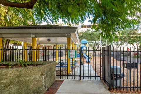 a park with a playground and a gated entrance