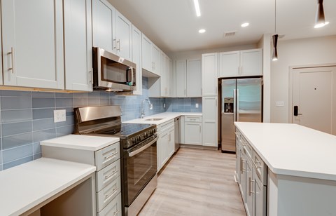 A modern kitchen with white cabinets and stainless steel appliances.