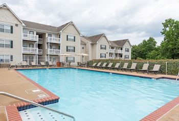 A large swimming pool in front of apartment buildings.