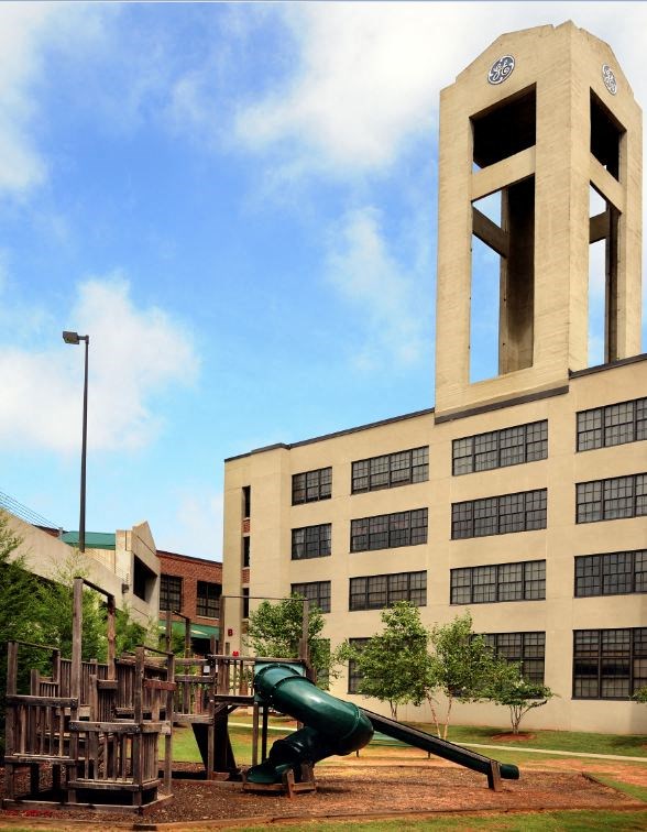 a playground with a large bell tower in the background