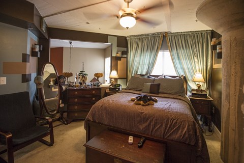 a bedroom with a bed and a dresser and a mirror