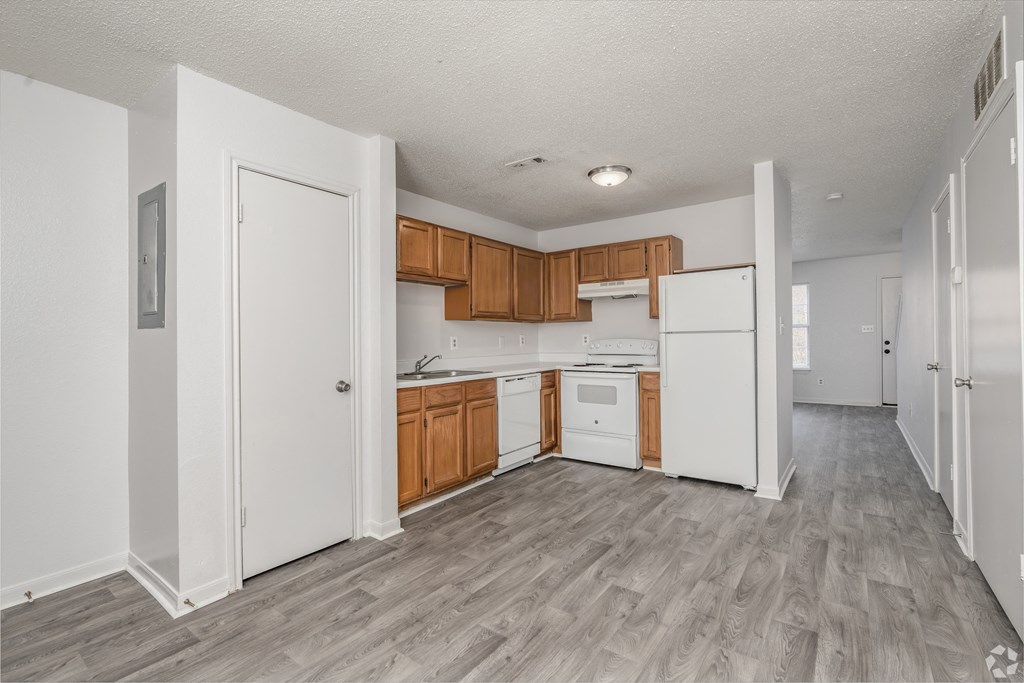 Kitchen with white appliances and wooden cabinets at Greens of Concord, Concord, NC, North Carolina, 28025