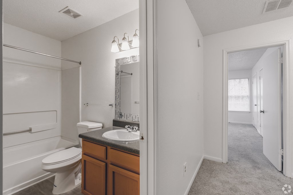 a bathroom with a toilet and a sink and a mirror at Greens of Concord, Concord, NC, North Carolina