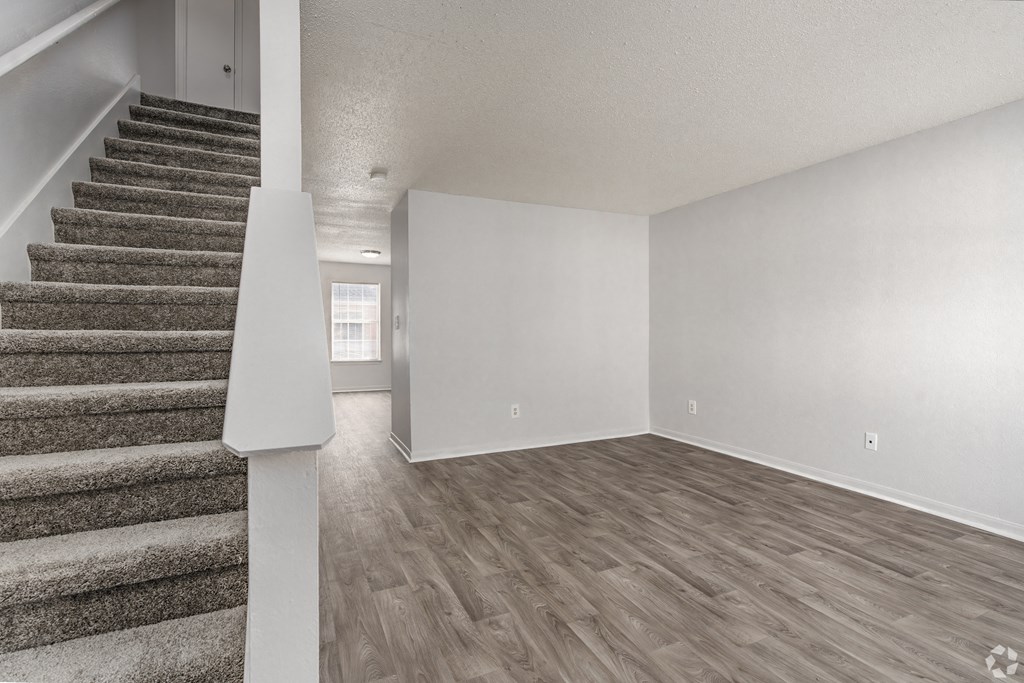 Living room and staircase of a renovated house and wood flooring at Greens of Concord, North Carolina, 28025