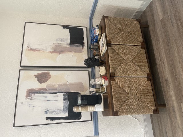 two paintings hanging on a wall next to a wooden shelf