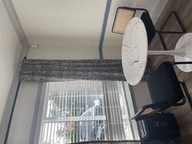 a living room with a window and a clock on the wall