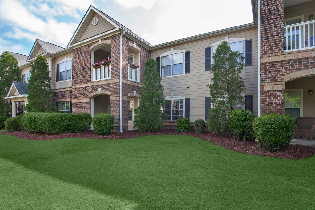 front view of a house with green lawn and shrubs at Carrington Place at Wildewood, Columbia, 29223  
