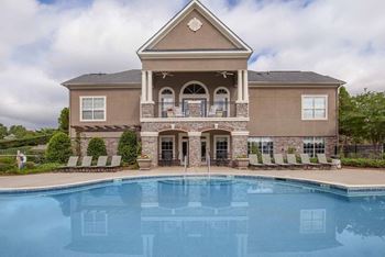 A large house with a pool in front.