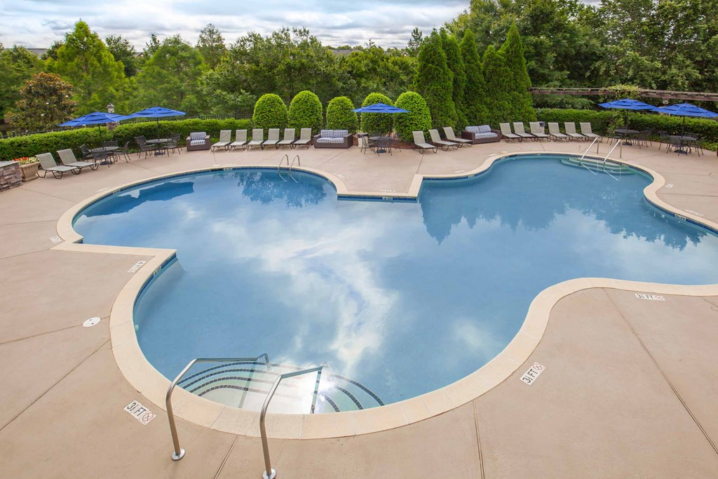 a swimming pool with chairs and umbrellas at a resort at Carrington Place at Wildewood, Columbia, 29223  