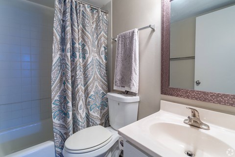 A white toilet sits next to a sink in a bathroom.at Bradley Square, North Charleston South Carolina   