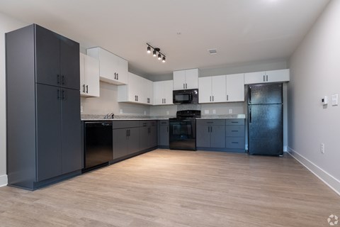 A kitchen with black cabinets and a wooden floor at Dunean Creek Apartments, Greenville