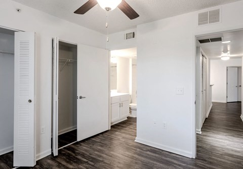 a bedroom with white walls and a ceiling fan