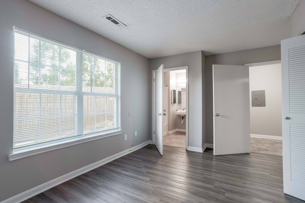 A room with a large window and wooden flooring.