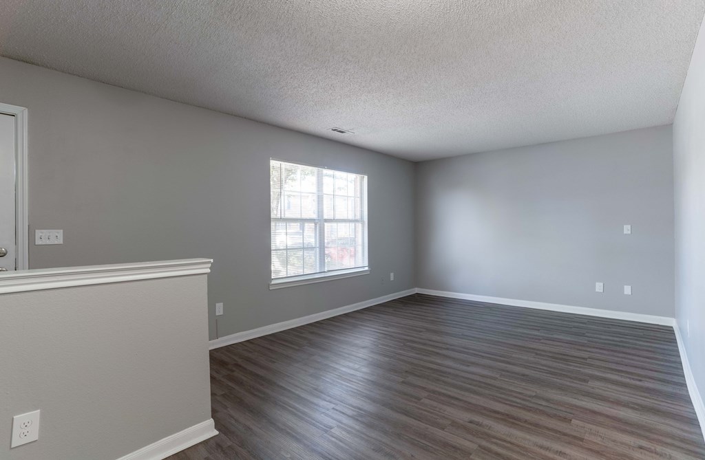 A room with wooden flooring and a window.