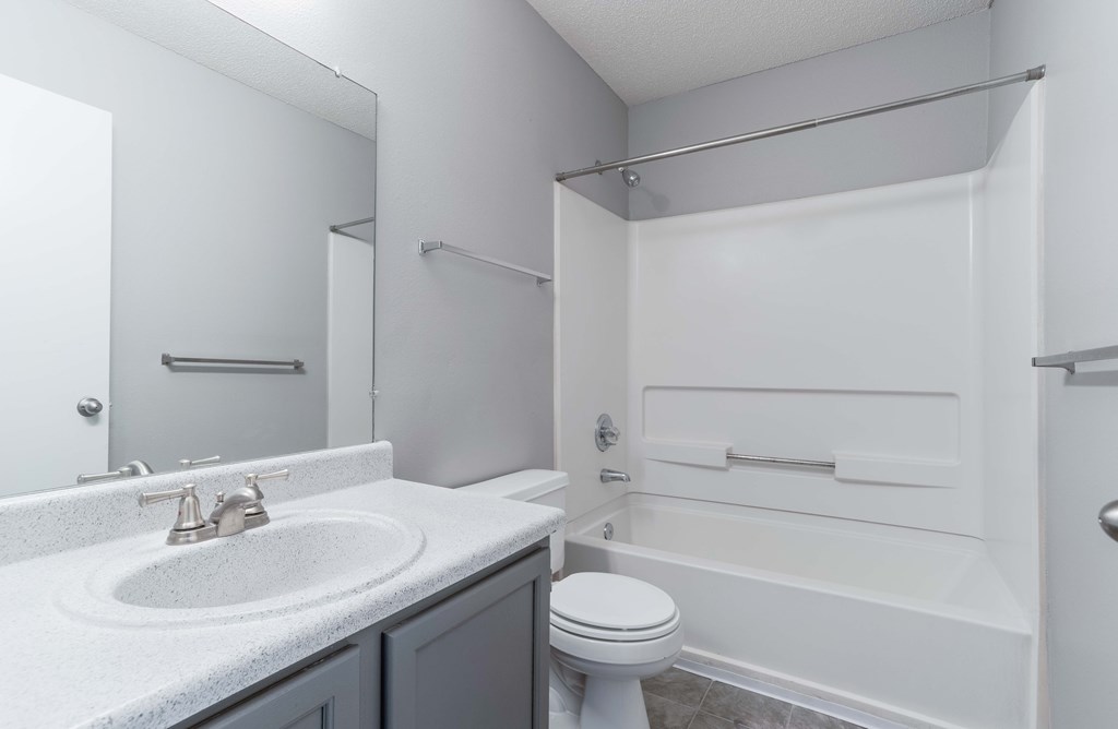 A white bathroom with a toilet, sink, and bathtub.