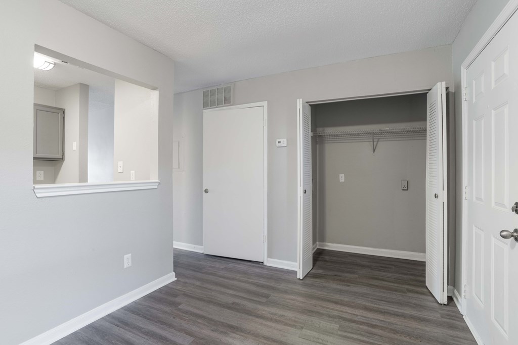 A room with a white door and a grey wall.