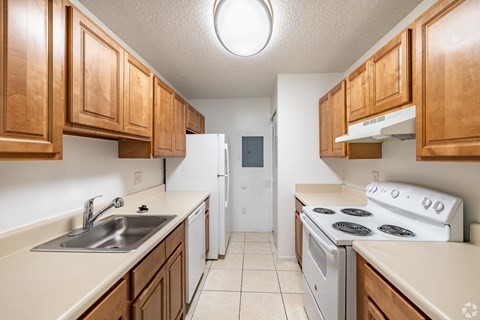 A kitchen with white appliances and wooden cabinets.
