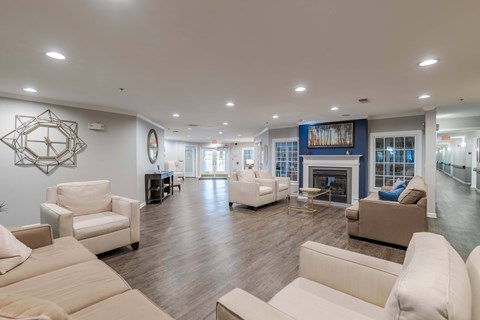 A living room with white furniture and a fireplace.