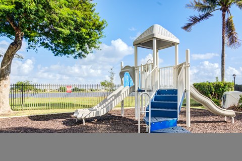 A playground with a white tower structure and a blue slide.