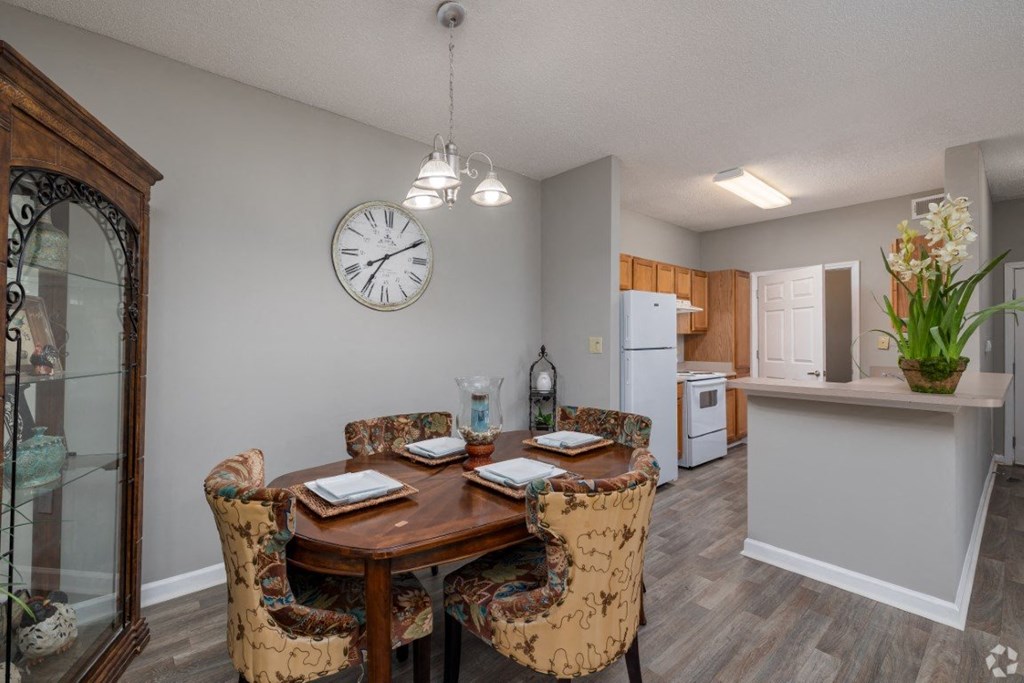 a dining room and kitchen with a large clock on the wall at Magnolia Lake Apartments, Georgia 30117