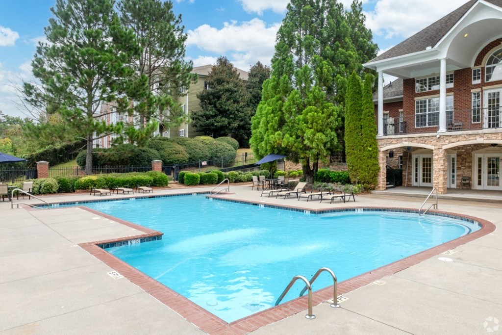 a large swimming pool in front of a building with a resort style pool at Magnolia Lake Apartments, Carrollton, Georgia