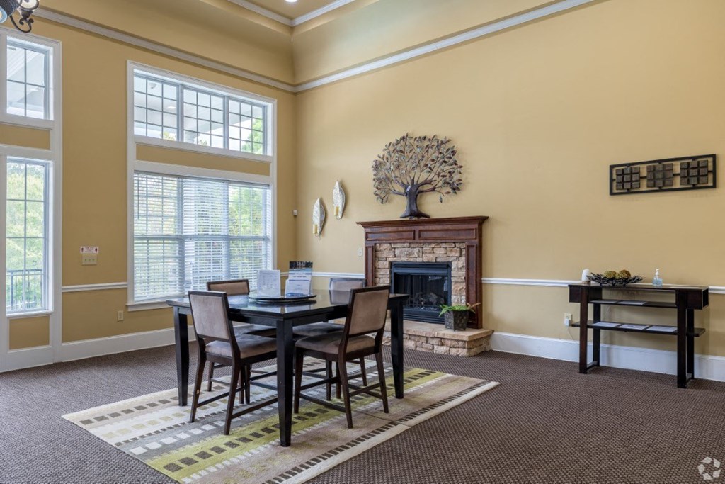 a dining room with a table and chairs in front of a fireplace at Magnolia Lake Apartments, Carrollton, Georgia