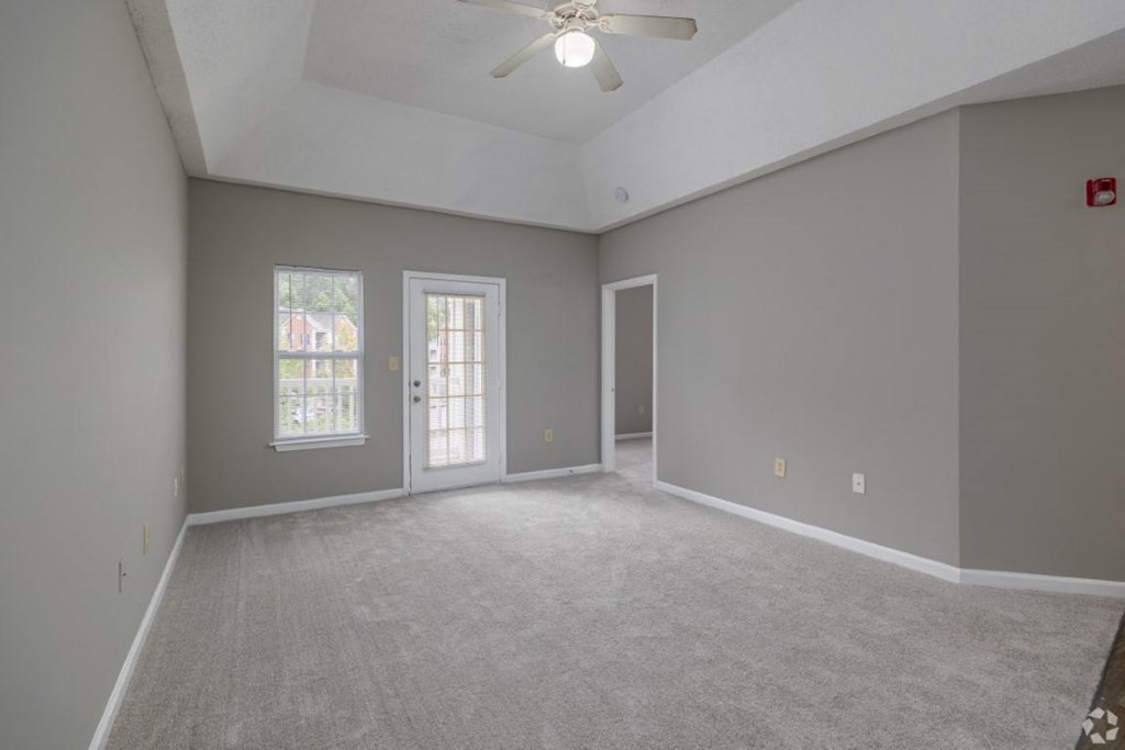 an empty living room with grey walls and a ceiling fan at Magnolia Lake Apartments, Carrollton, Georgia