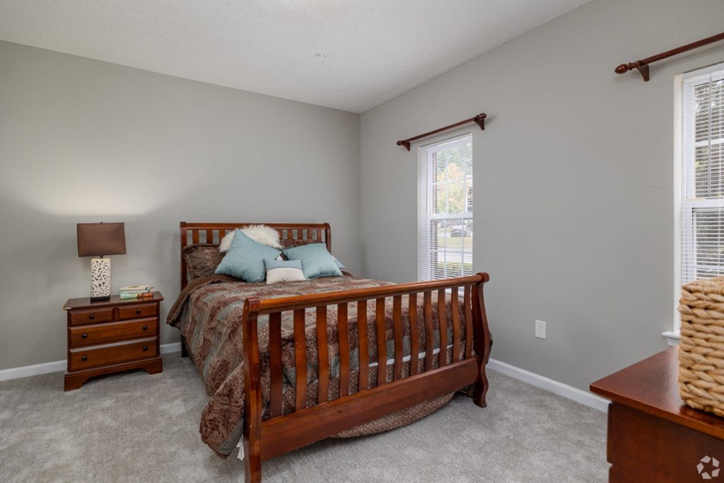 a bedroom with a bed and two windows at Magnolia Lake Apartments, Georgia