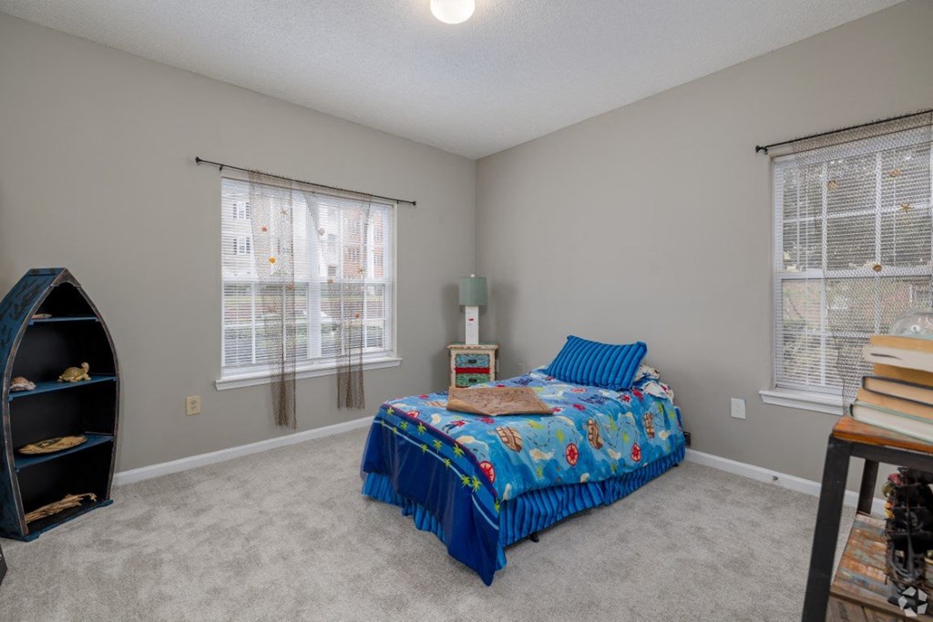 a bedroom with a bed and two windows at Magnolia Lake Apartments, Georgia 30117