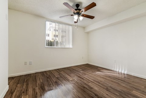 a bedroom with hardwood flooring and a ceiling fan