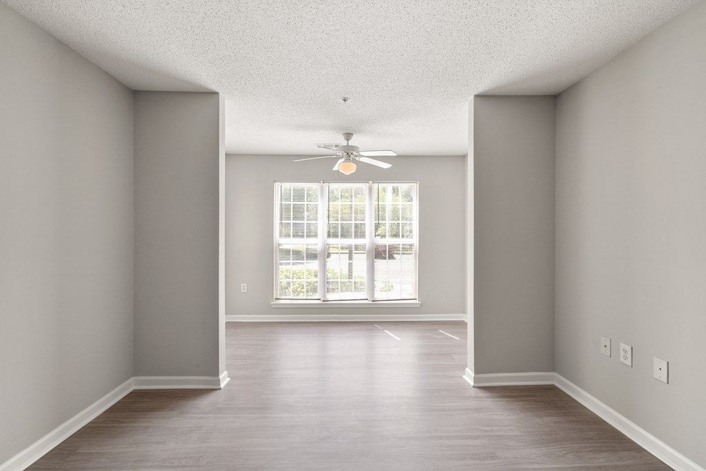 an empty living room with a ceiling fan at Palms on Ashley River Apartments, Ladson, South Carolina