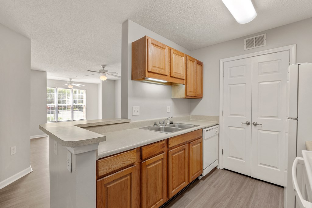 a kitchen with white appliances and wooden cabinets a kitchen with white appliances and wooden cabinets at Palms on Ashley River Apartments, Ladson, 29456