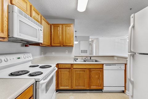a kitchen with white appliances and wooden cabinets