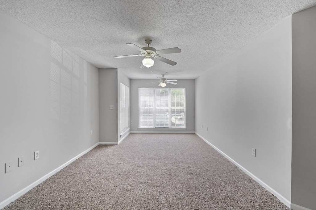 an empty room with a ceiling fan and a window at Palms on Ashley River Apartments, Ladson, 29456