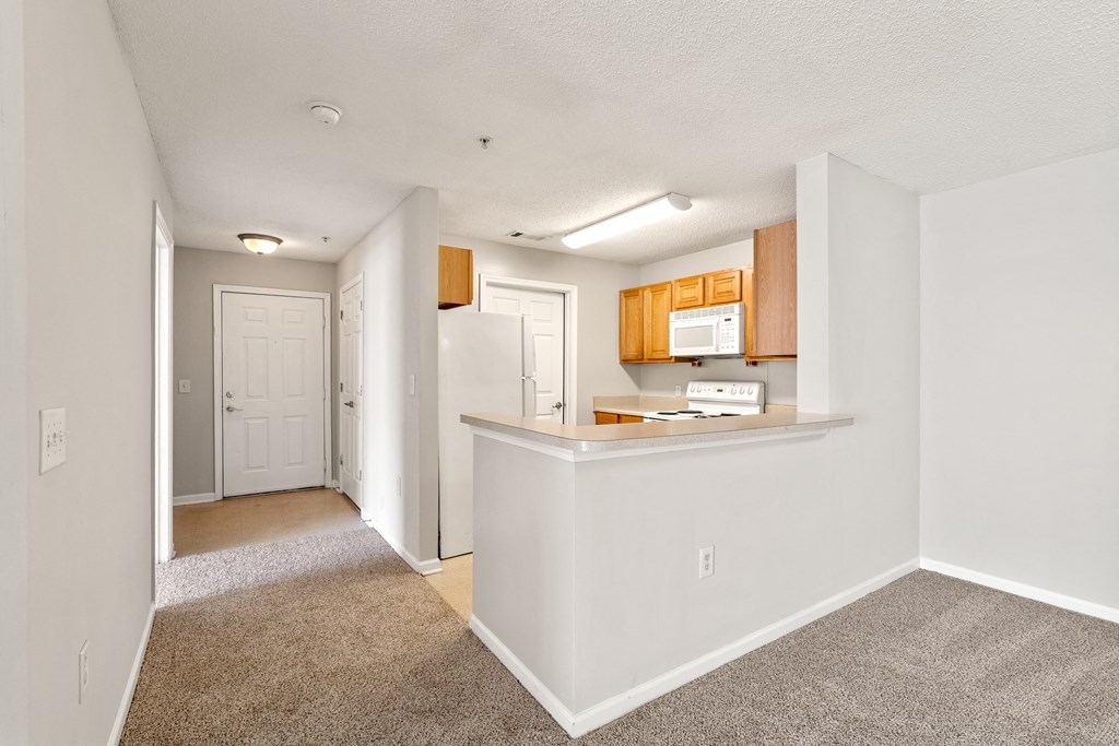 a kitchen and hallway with a carpeted floor a kitchen and hallway with a carpeted floor at Palms on Ashley River Apartments, South Carolina