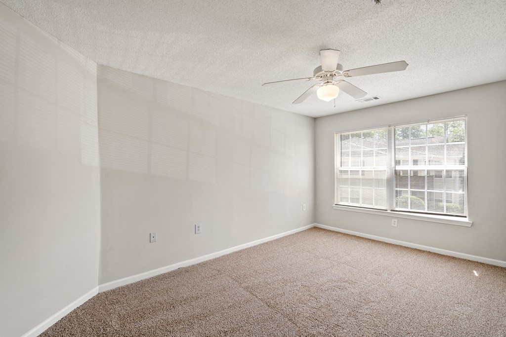 a bedroom with a ceiling fan and a window at Palms on Ashley River Apartments, Ladson, South Carolina