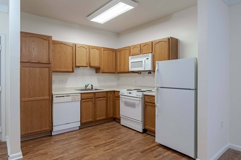 A kitchen with wooden cabinets and white appliances.