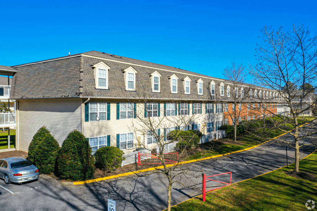 a large apartment building with cars parked in front of it