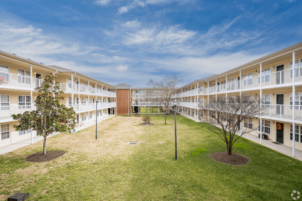 an open courtyard in an apartment building with grass and trees