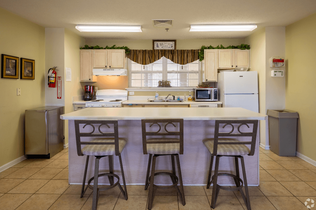 a kitchen with a large island with three chairs