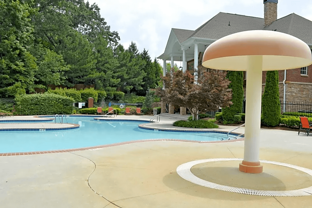 a pool with a pool umbrella in front of a house