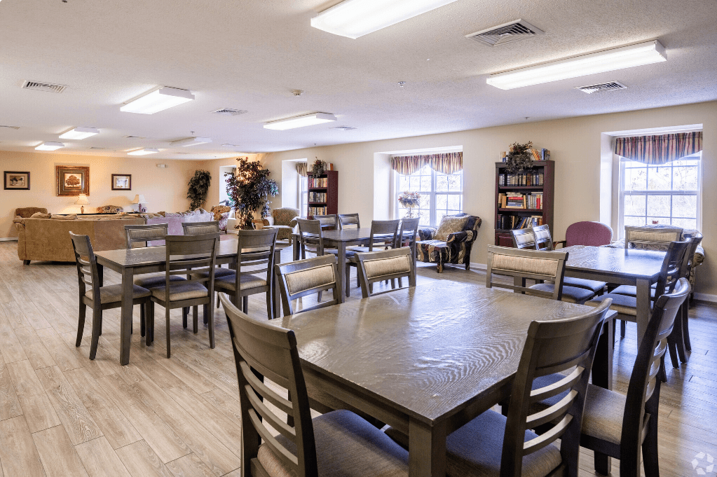 a dining room with tables and chairs and a living room with a couch