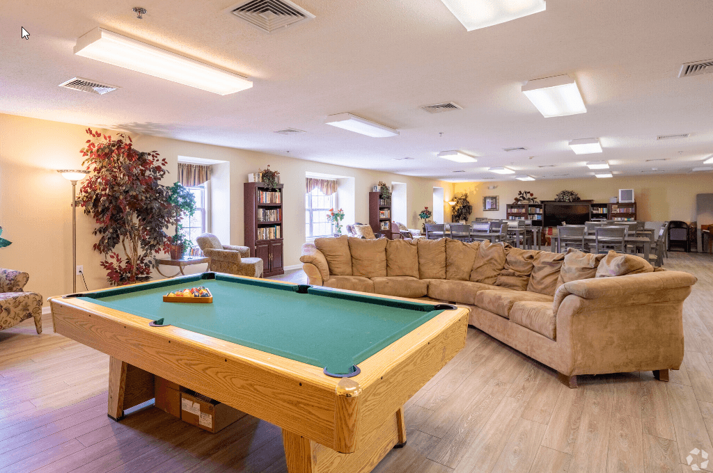 a game room with a pool table and couches
