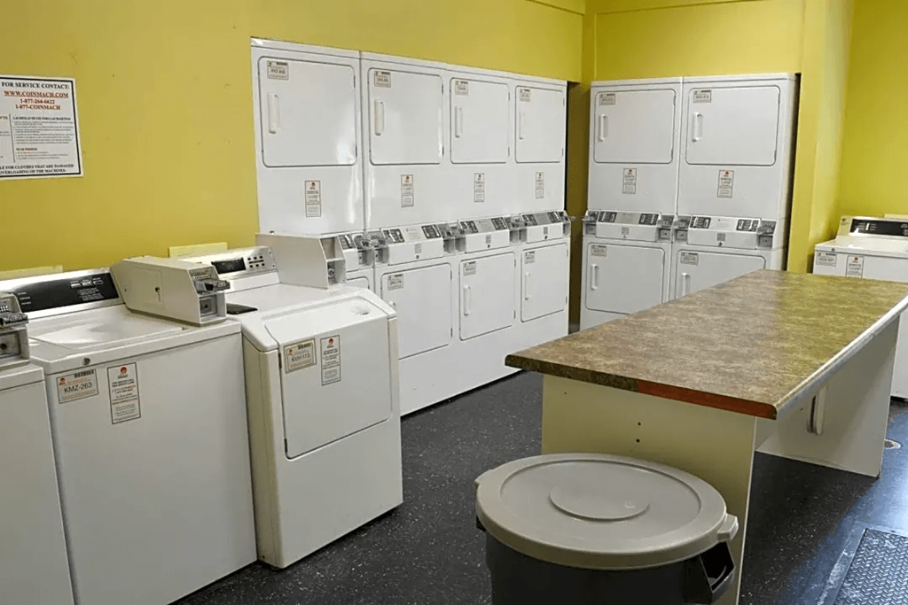 a row of washing machines and dryers in a utility room